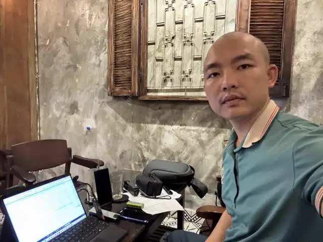 Cao Thái Toàn làm việc với laptop buổi tối tại quán cà phê Sài Gòn